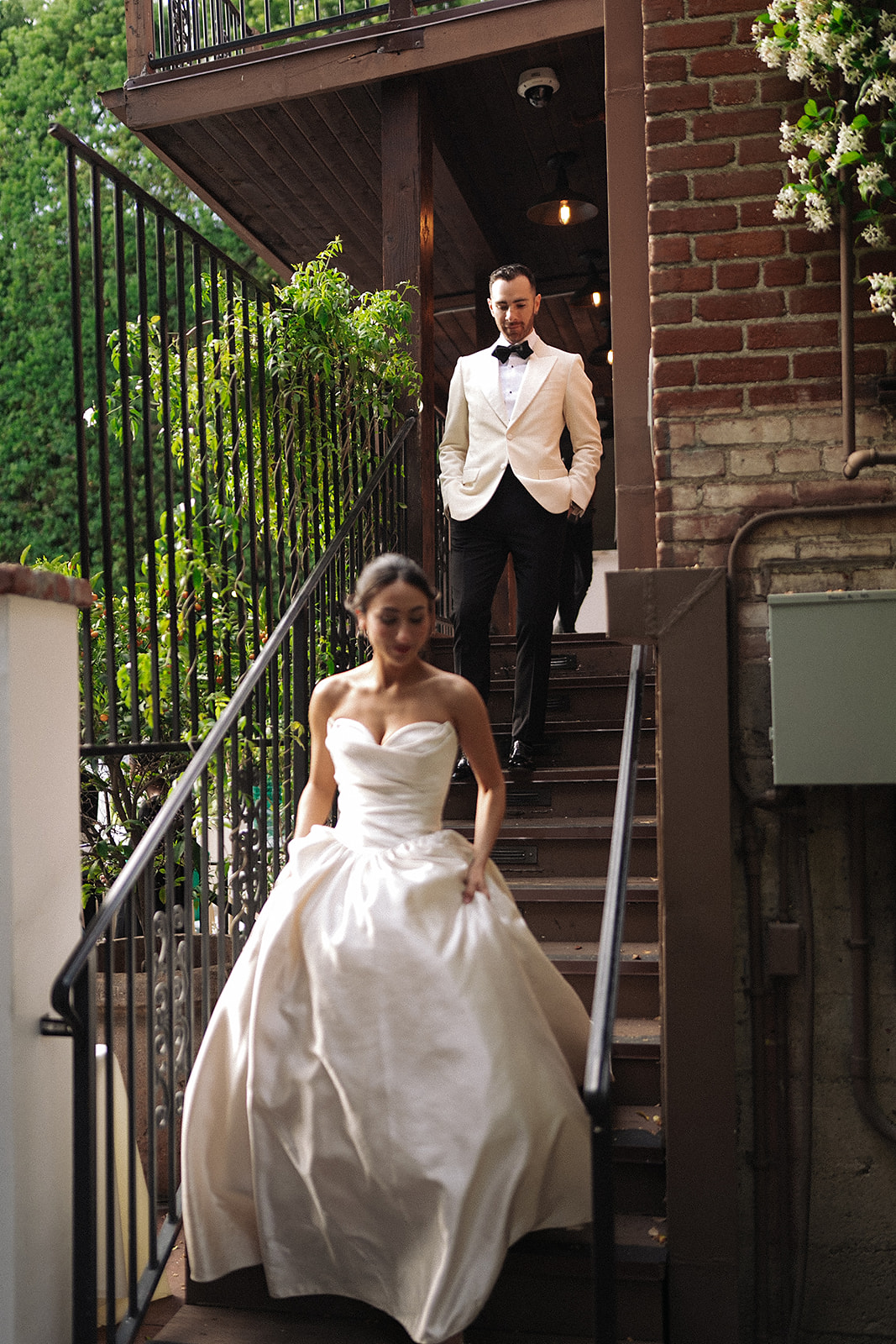 Wedding couple running down stairs.